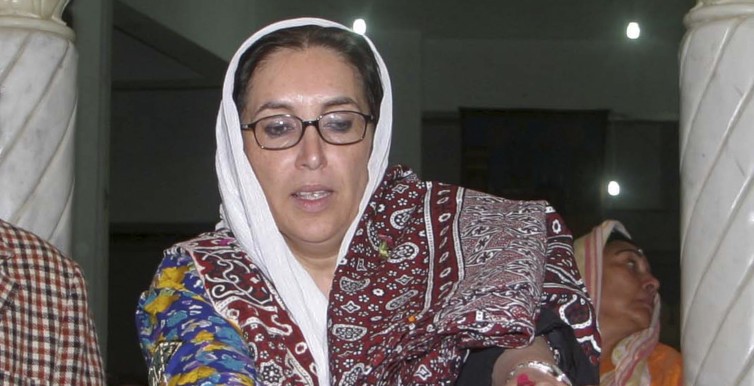 File photo shows former Pakistan prime minister Bhutto laying flowers at the grave of her father near Larkana